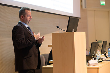 Image showing Speaker giving talk on podium at Business Conference.