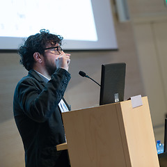 Image showing Speaker giving talk on podium at Business Conference.