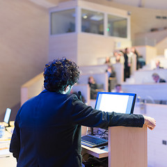 Image showing Speaker giving talk on podium at Business Conference.