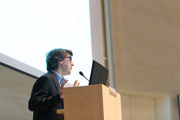 Image showing Speaker giving talk on podium at Business Conference.