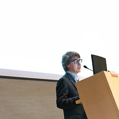 Image showing Speaker giving talk on podium at Business Conference.