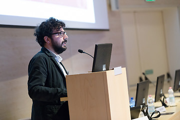 Image showing Speaker giving talk on podium at Business Conference.