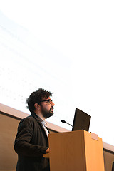 Image showing Speaker giving talk on podium at Business Conference.