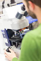 Image showing Scientist microscoping on fluorescent microscope. 