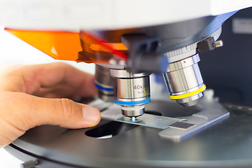 Image showing Scientist microscoping on fluorescent microscope. 