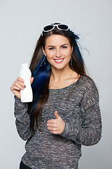 Image showing Healthy woman showing a bottle of dairy produce