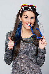 Image showing Smiling woman wearing many colourful sunglasses