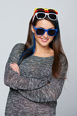 Image showing Smiling woman wearing many colourful sunglasses