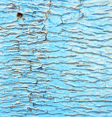 Image showing dirty stripped paint in the blue wood door and rusty nail