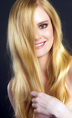 Image showing Beautiful Smiling Blond Woman Grooming Brushing Her Hair