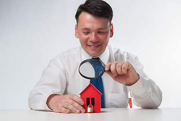 Image showing Man with a magnifying glass and paper house