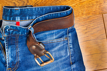 Image showing blue jeans with a leather belt