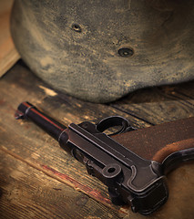 Image showing pistol Parabellum and vintage German soldier helmet