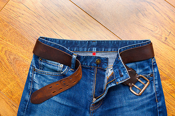 Image showing Aged blue jeans with a leather belt