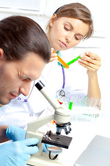 Image showing Female researcher analyzes tubes