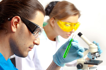 Image showing Male researcher analyzes tubes