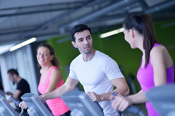 Image showing Group of people running on treadmills