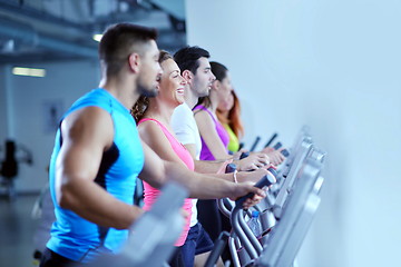 Image showing Group of people running on treadmills