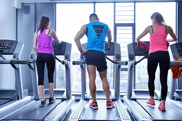 Image showing Group of people running on treadmills