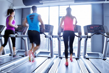 Image showing Group of people running on treadmills