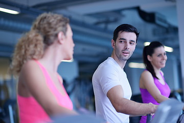 Image showing Group of people running on treadmills