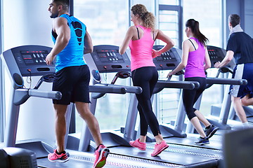 Image showing Group of people running on treadmills