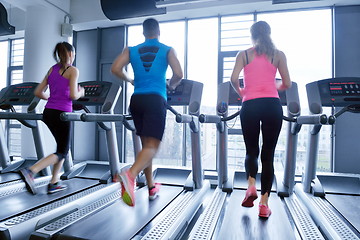 Image showing Group of people running on treadmills