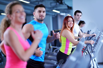 Image showing Group of people running on treadmills