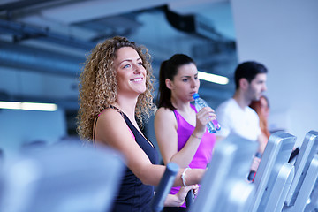 Image showing Group of people running on treadmills