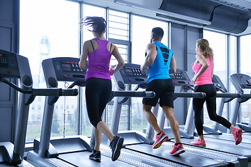 Image showing Group of people running on treadmills