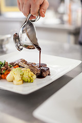 Image showing Chef plating up food in a restaurant