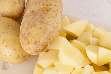 Image showing Whole Potatoes and Chopped Pieces on Cutting Board