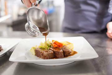 Image showing Chef plating up food in a restaurant