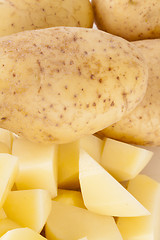 Image showing Whole Potatoes and Chopped Pieces on Cutting Board