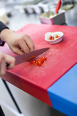 Image showing Chef dicing red hot chili peppers