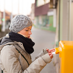 Image showing Young lady posting letters. 