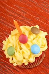 Image showing Fancy birthday cupcake with orange candle