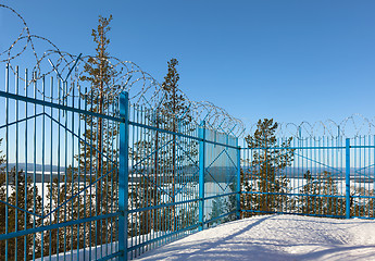 Image showing closed area behind a fence topped with barbed wire