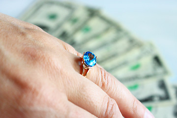 Image showing Hand with topaz on the finger and dollars