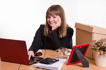 Image showing Smiling girl sitting in office at computer