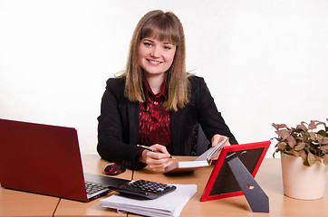 Image showing Joyful Girl sitting at office table