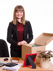 Image showing Girl standing behind an office desk with a big box