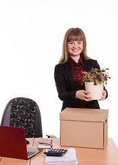 Image showing Girl office about desktop keeps indoor flower in pot
