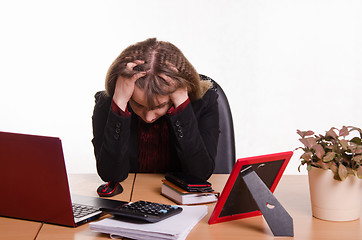 Image showing girl behind office desk grabbed head in his hands