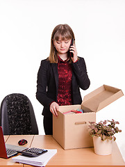 Image showing Girl in office examines personal things and calling on phone