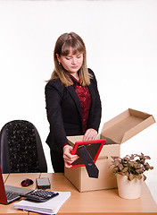 Image showing Girl in office collects, parses personal belongings a box