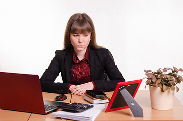 Image showing Thoughtful girl sitting at office desk
