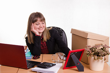 Image showing Smiling office employee looks at the picture frame