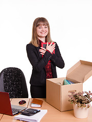 Image showing Girl puts a photo frame on desktop in office