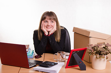 Image showing Dreamy girl sitting at office desk